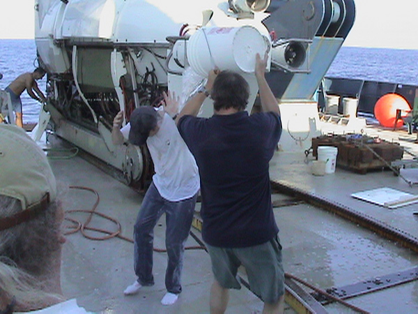 Joe Haberstroh, a Newsday reporter, gets doused with ice-cold seawater by Ivar Babb upon returning from his first ever Alvin submersible dive.