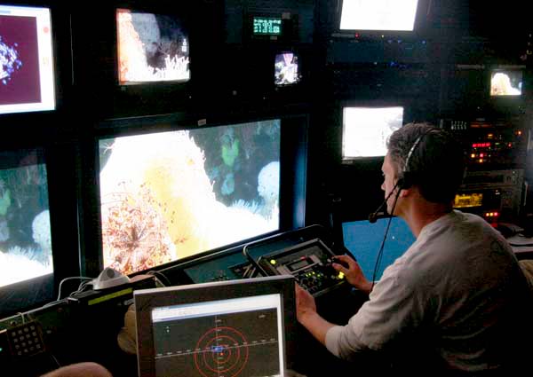 Huff McGonigal takes his turn in the science chair. The large plasma screen in front of him displays the HD video from the ROV.