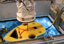 A crane releases the Tiburon through the moonpool doors in the launch bay floor.