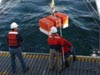 Cruise participants deploy the acoustic Doppler current profiler (a type of current meter) from the aft deck of the research vessel Western Flyer.