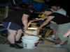 Upon ROV recovery to the surface, Jason pilot Bob Waters helps Stephanie Lessard-Pilon and Julia Zekely quickly collect samples from a well-lit biobox.