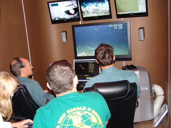 ROV pilots Matthew Cook and Geoff Cook watch the monitors inside the van with chief scientist Erik Cordes and research technician Leslie Wickes. 