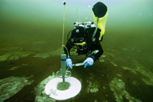 Joe Hoyt, sets up a respiration chamber experiment near the purple microbial mats