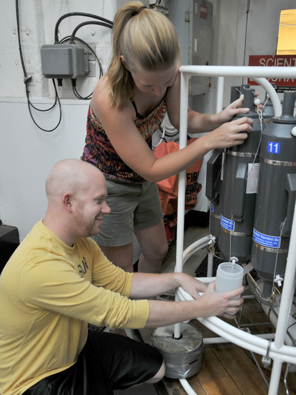 Jay Lunden gets help from Lara Miles in collecting water samples