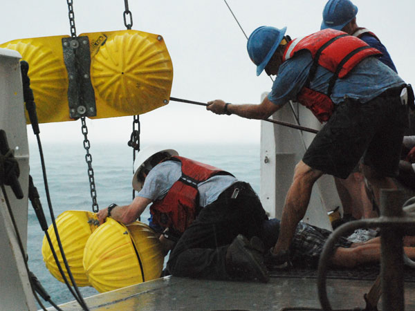 Crew of the RV Ron Brown deploying floats on sediment trap mooring. 