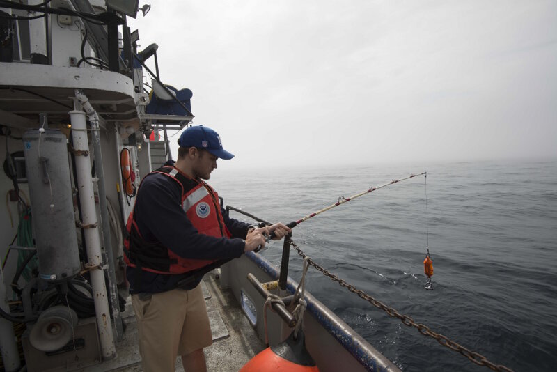 University of Delaware sonar technician Peter Barron prepares to lower a device that will measure the speed of sound throughout the entire water column.