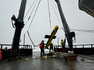 Surveyors from Thayer Mahan and vessel crew from Support Vessels of Alaska are seen lowering the SeaScout-2, which carried the synthetic aperture sonar and multibeam echosounder.