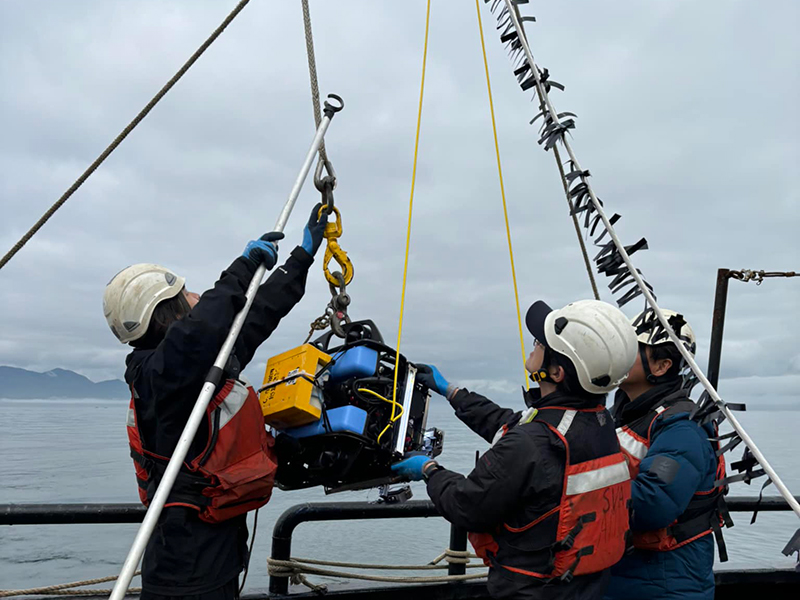 Researchers reach for the BlueROV, a small remotely operated vehicle used during the expedition.