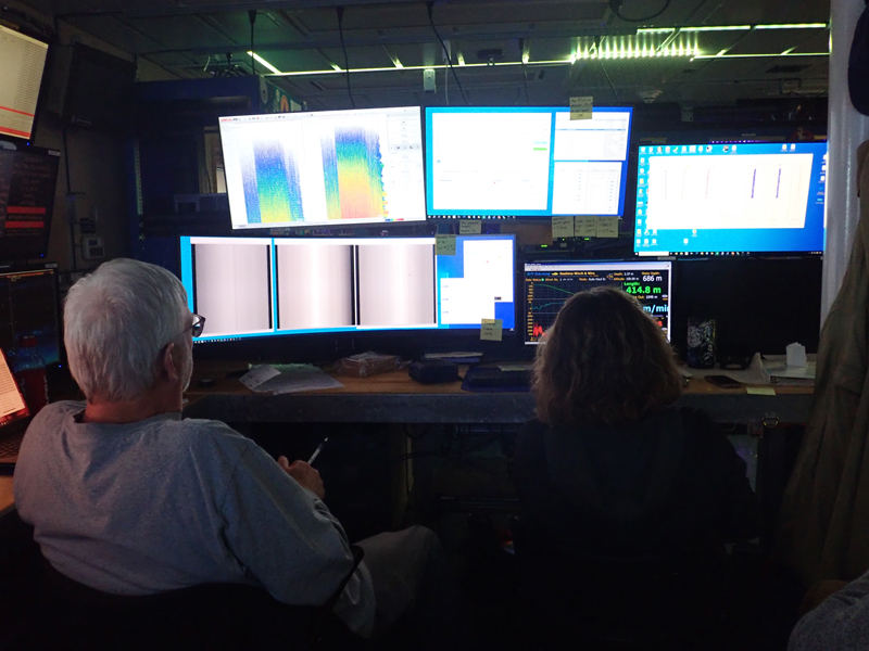 John Horne and Hannah Kepner watch the live acoustic and shadowgraph data from the In-Situ Ichthyoplankton Imaging System Deep-Focus Particle Imager (ISIIS-DPI) during the Exploring Pelagic Biodiversity of the Gulf of Alaska and the Impact of Its Seamounts expedition.