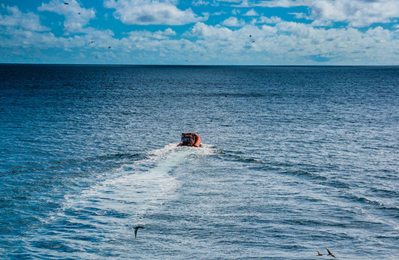 Okeanos Explorer’s fast rescue boat is deployed from the ship and en route to Tern Island to pick up four Monk Seal Researchers.